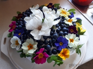 Tort bezowy  z borówkami, kwiatami magnoli,  pierwiosnków, miętą i melisą 